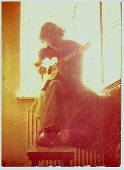 Der junge Mike Schaefer mit der Gitarre am Fenster